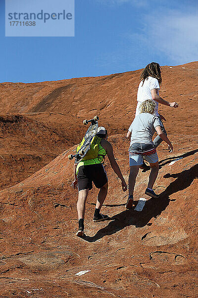 Skateboarder  die mit ihrem Skateboard auf den Uluru  früher bekannt als Ayers Rock  fahren; Northern Territory  Australien