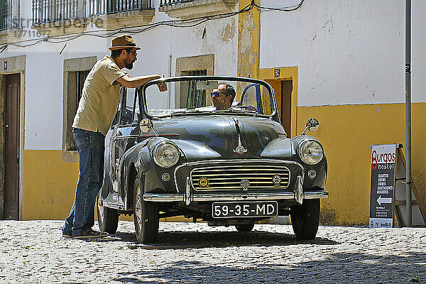 Männer unterhalten sich in einem Oldtimer auf den Straßen von Portugal; Portugal