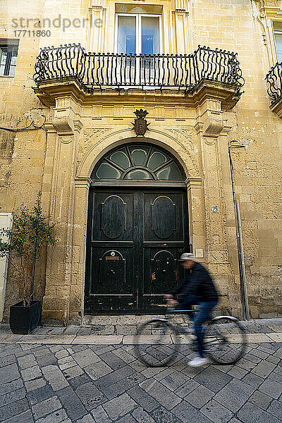 Ein Mann fährt mit dem Fahrrad durch das historische Zentrum von Lecce  Italien; Lecce  Apulien  Italien