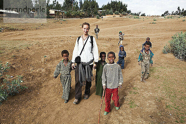 Junge Trekkerin beim Wandern mit einheimischen Kindern in den Simien-Bergen; Äthiopien