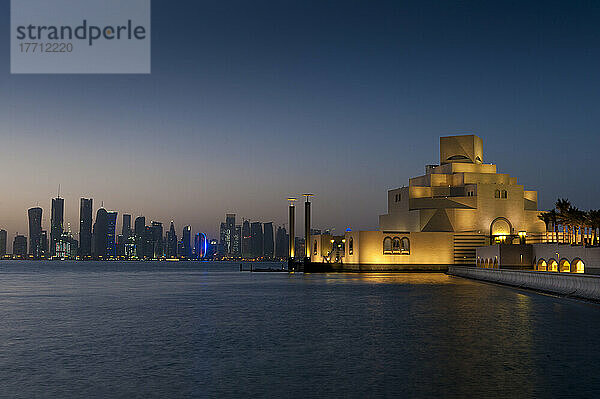 Museum für Islamische Kunst in der Abenddämmerung mit moderner Stadtsilhouette dahinter; Doha  Katar