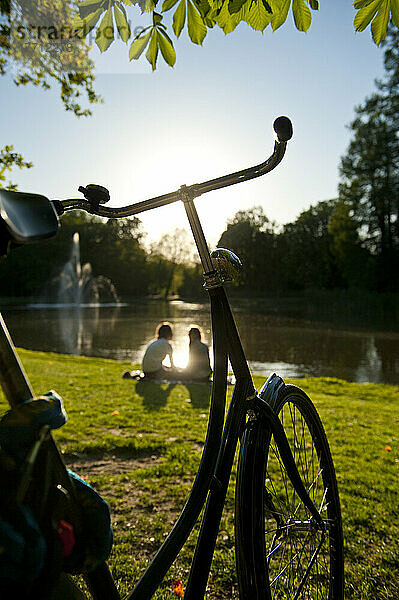 Paar entspannt sich neben dem See im Vondelpark am Abend; Amsterdam  Holland