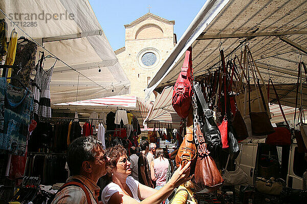 Einkaufen auf dem lokalen Markt auf dem Platz von San Gimignano  einer berühmten mittelalterlichen Stadt auf einem Hügel in der Toskana. Italien. Juni.
