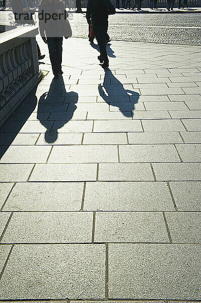 Fußgänger und ihr Schattenwurf auf einem Gehweg im Marais-Viertel; Paris  Frankreich