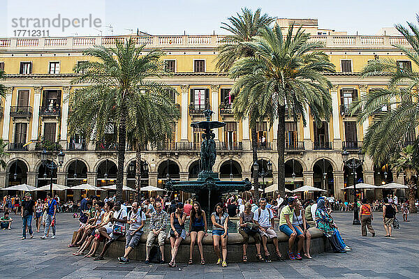 Menschen  die am Rand eines Wasserbrunnens auf der Plaza Real sitzen; Barcelona  Katalonien  Spanien