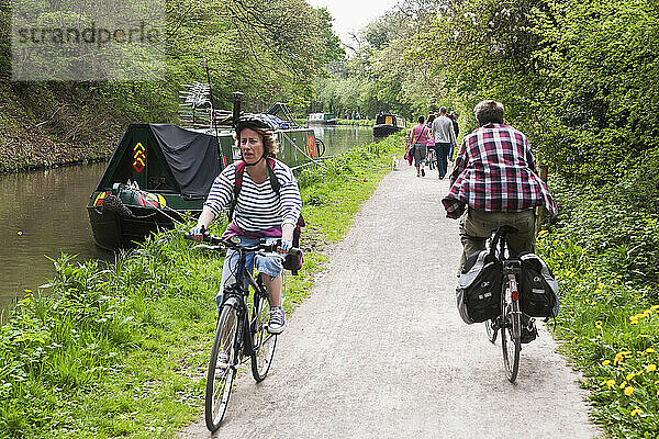 Radfahrer entlang des Kanals  vorbei an einem Schmalspurboot  in der Nähe von Bath; Somerset  England