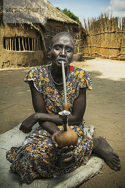 Nuer-Frau beim Rauchen einer traditionellen Pfeife  Westäthiopien; Äthiopien