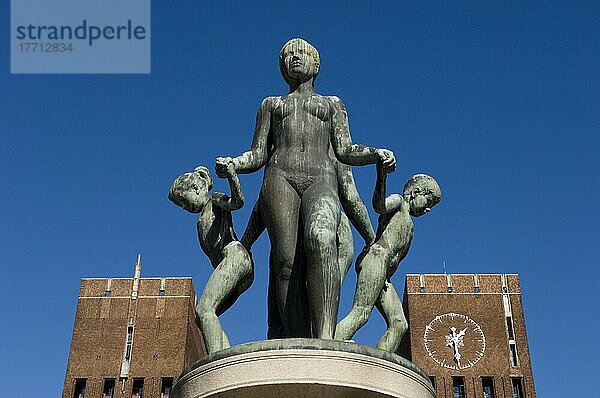 Außenansicht des Osloer Rathauses mit einer Statue einer Frau  die mit Kindern Händchen hält