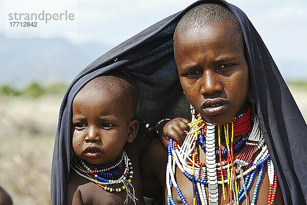 Ein junger Mann und ein kleines Kind tragen bunten Perlenschmuck; Omo-Tal  Äthiopien