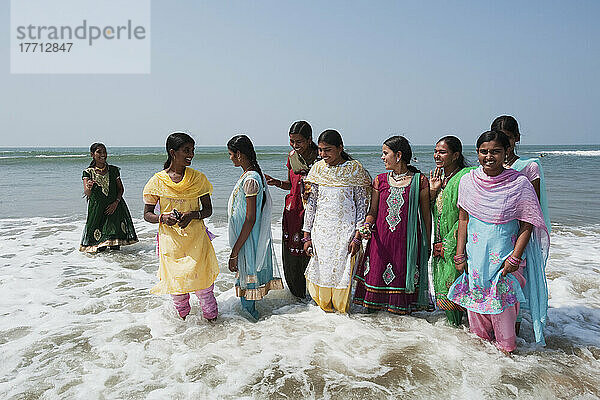 Frauen in ihren Saris  die in der Brandung am Rande des Wassers stehen; Gokarna  Karnataka  Indien