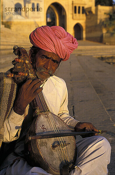 Musiker spielt traditionelles Saiteninstrument  Gadi Sagar Tank; Jaisalmer  Indien