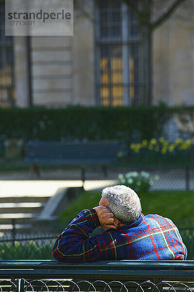 Ein Mann sitzt entspannt auf einer Parkbank im Marais-Viertel; Paris  Frankreich