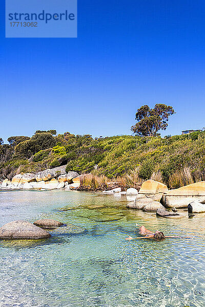 Eine junge Frau schwimmt am Bay Of Fires Beach; Tasmanien  Australien