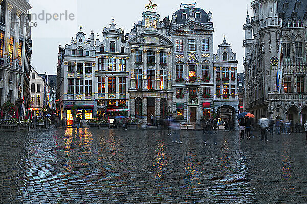 Fußgänger  die durch einen nassen Stadtplatz gehen; Brüssel  Belgien