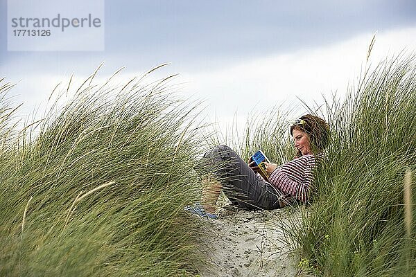 Frau liest am Strand