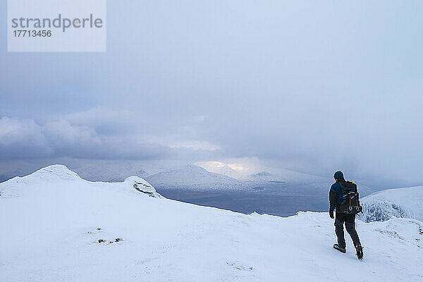 Mann beim Wandern auf dem Beinn Dorain bei verschneiten  winterlichen Bedingungen in der Nähe der Bridge of Orchy; Argyll und Bute  Schottland