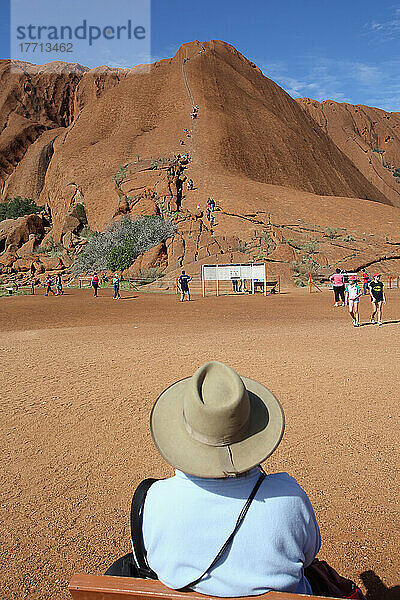 Touristen beobachten  wie Menschen den Uluru besteigen  früher bekannt als Ayers Rock; Northern Territory  Australien