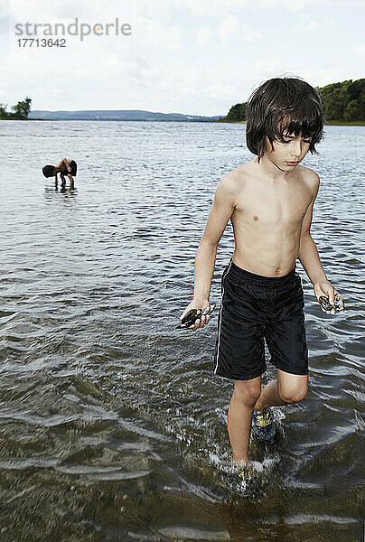 4 und 6 Jahre alt  die im Wasser spielen und Muschelschalen sammeln; Montreal  Quebec  Kanada