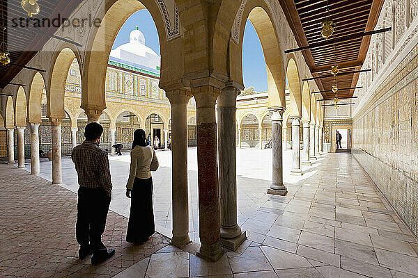 Ein junges Paar steht an der Schwelle des ersten Hofes in der Moschee des Barbiers; Kairouan  Tunesien  Nordafrika