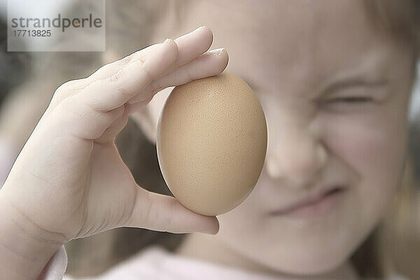 Mädchen hält Ei hoch