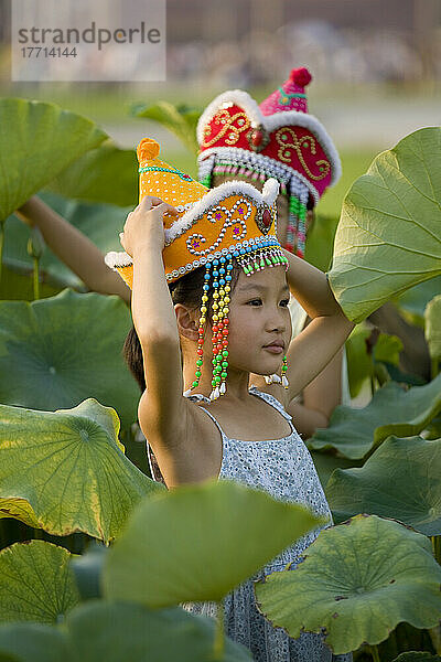 Junge Mädchen spielen zwischen Lotuspflanzen auf dem Platz des Himmlischen Friedens in Peking  China