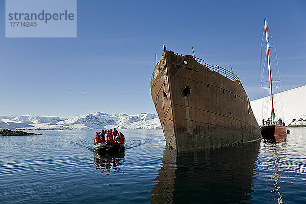 Reisende passieren den verrosteten Rumpf eines schiffbrüchigen Walfangschiffs in der Wilhelmina-Bucht vor der Enterprise-Insel  Antarktische Halbinsel
