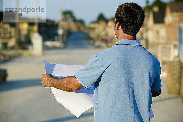 Architekt beim Lesen von Bauplänen auf einer Baustelle  Region York  Ontario