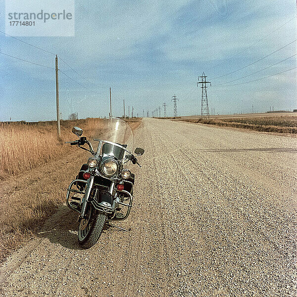 Am Rande einer Schotterstraße auf dem Land geparktes Motorrad; Manitoba  Kanada