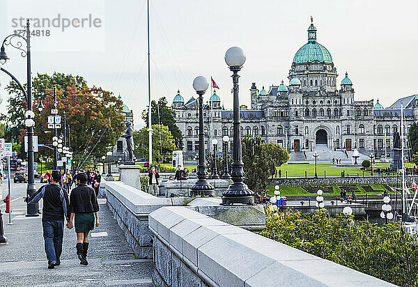 Ein junges Touristenpaar  das an der Uferpromenade in Richtung der Parlamentsgebäude spaziert; Victoria  Vancouver Island  British Columbia