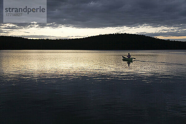 Frau paddelt alleine bei Sonnenuntergang  Algonquin Park  Ontario