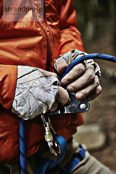 Mann beim Einstellen der Kletterausrüstung in den Adirondacks; New York  USA