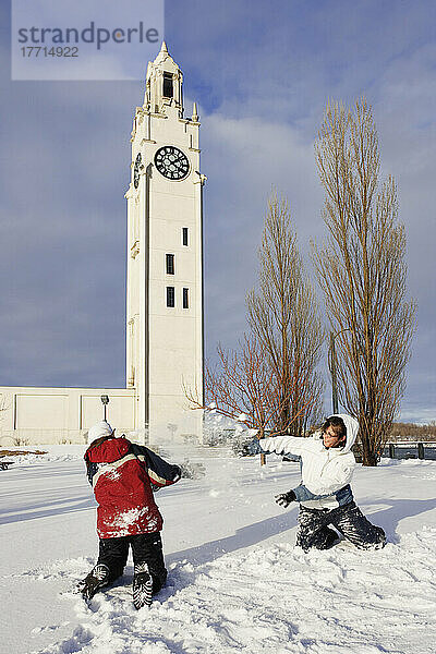 Mädchen spielen im Schnee mit Uhrenturm im Hintergrund