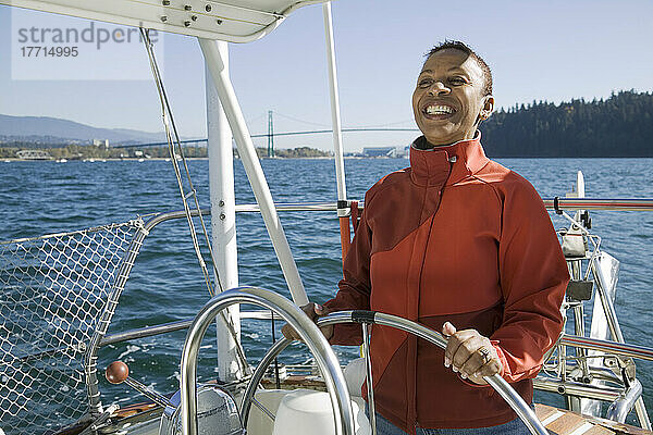 Ältere Frau steuert ihr Segelboot  Hafen von Vancouver  Bc