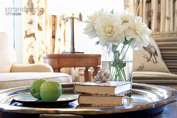 Tablett mit Blumen  Büchern und grünen Äpfeln