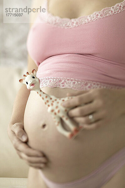 Schwangere Frau hält Spielzeug