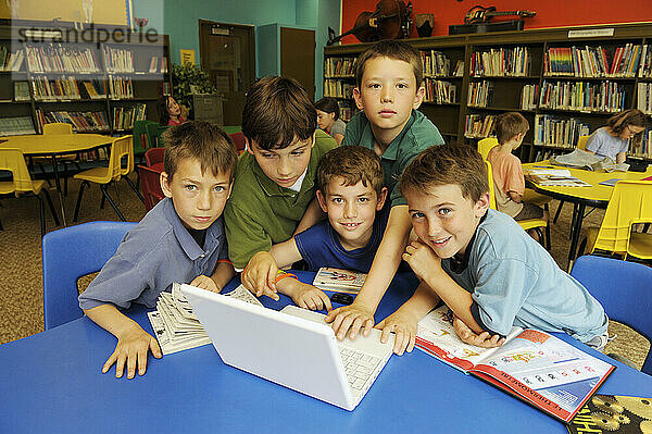 Junge Jungen betrachten Laptop in Schulbibliothek  Toronto  Ontario
