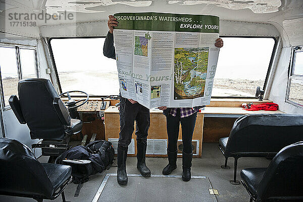 Zwei Menschen  die eine Karte auf einem Tundra-Buggy betrachten; Churchill  Manitoba  Kanada