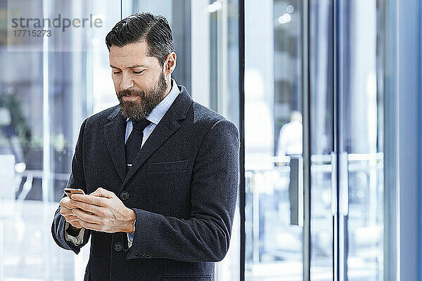 Geschäftsmann im Anzug  der im Freien auf sein Handy schaut; Toronto  Ontario  Kanada