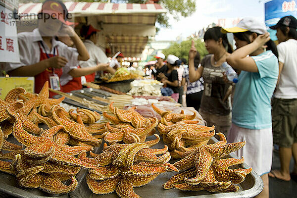 Lebensmittelverkäufer bieten entlang einer Straße in Peking exotische Köstlichkeiten zum Verkauf an  China
