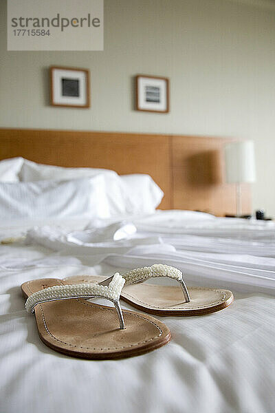 Sandalen und Hochzeitskleid auf dem Hotelbett