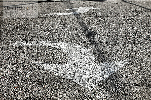 Zwei Pfeile auf der Straße mit Schatten über ihnen