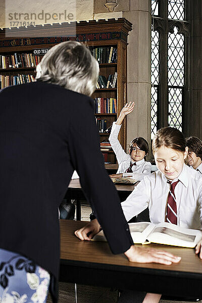 Lehrer im Gespräch mit Schülern im Klassenzimmer