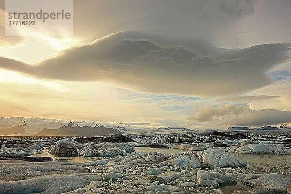 Die schmelzenden Eisberge von Jokulsarl auf der Gletscherlagune in Südisland mit linsenförmigen Wolken über ihnen