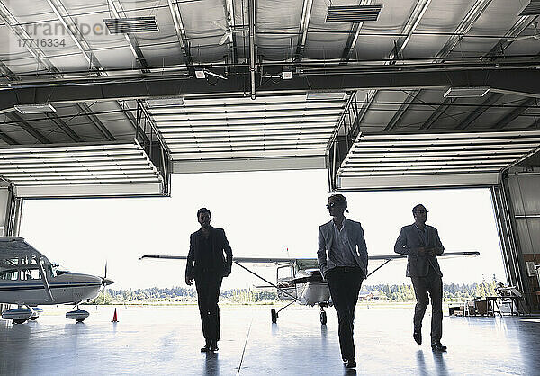 Drei Geschäftsleute beim Betreten eines Flugzeughangars; Langley  British Columbia  Kanada