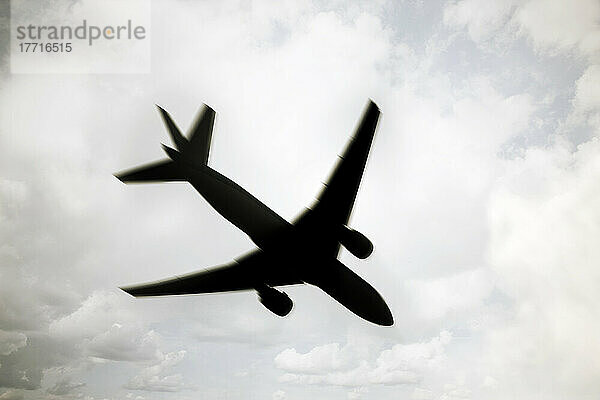 Silhouette des Flugzeugs in bewölktem Himmel