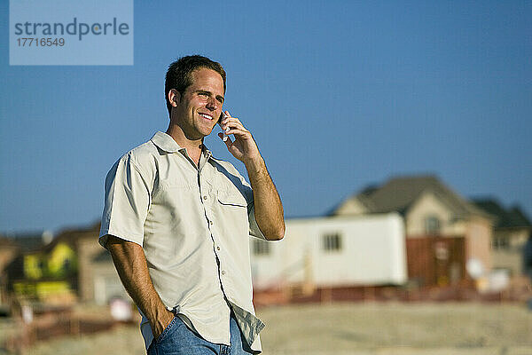 Ingenieur  der auf einer Baustelle mit einem Mobiltelefon spricht  Region York  Ontario