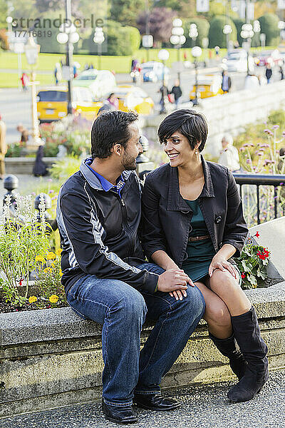 Ein junges indischstämmiges Paar sitzt romantisch lächelnd zusammen; Victoria  Vancouver Island  British Columbia