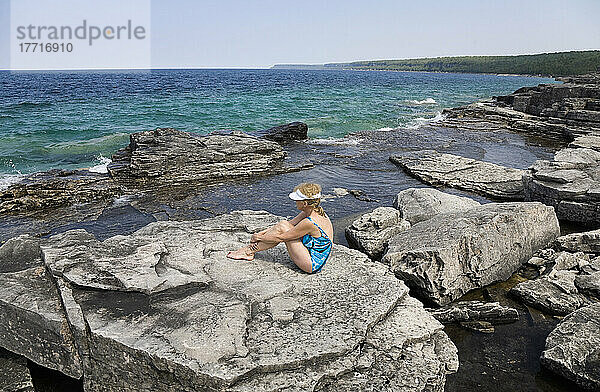 Frau beim Sonnenbaden an einem felsigen Strand mit Blick auf die Georgian Bay im Bruce Peninsula National Park; Ontario  Kanada