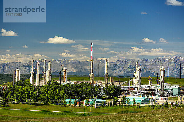 Gasraffinerie mit Bergen  blauem Himmel und Wolken im Hintergrund  nördlich von Cochrane; Alberta  Kanada
