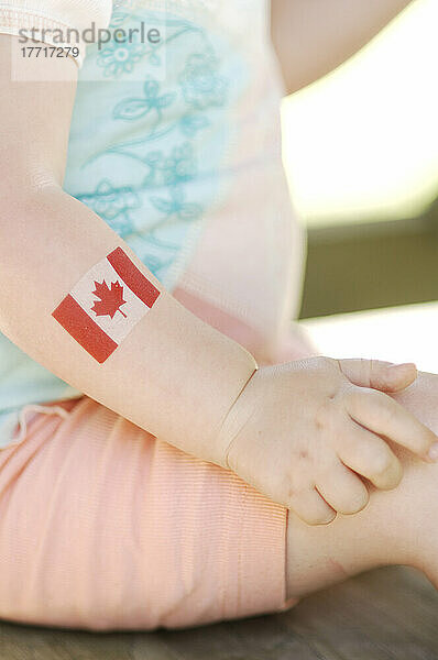Kleines Mädchen mit kanadischer Flagge am Arm